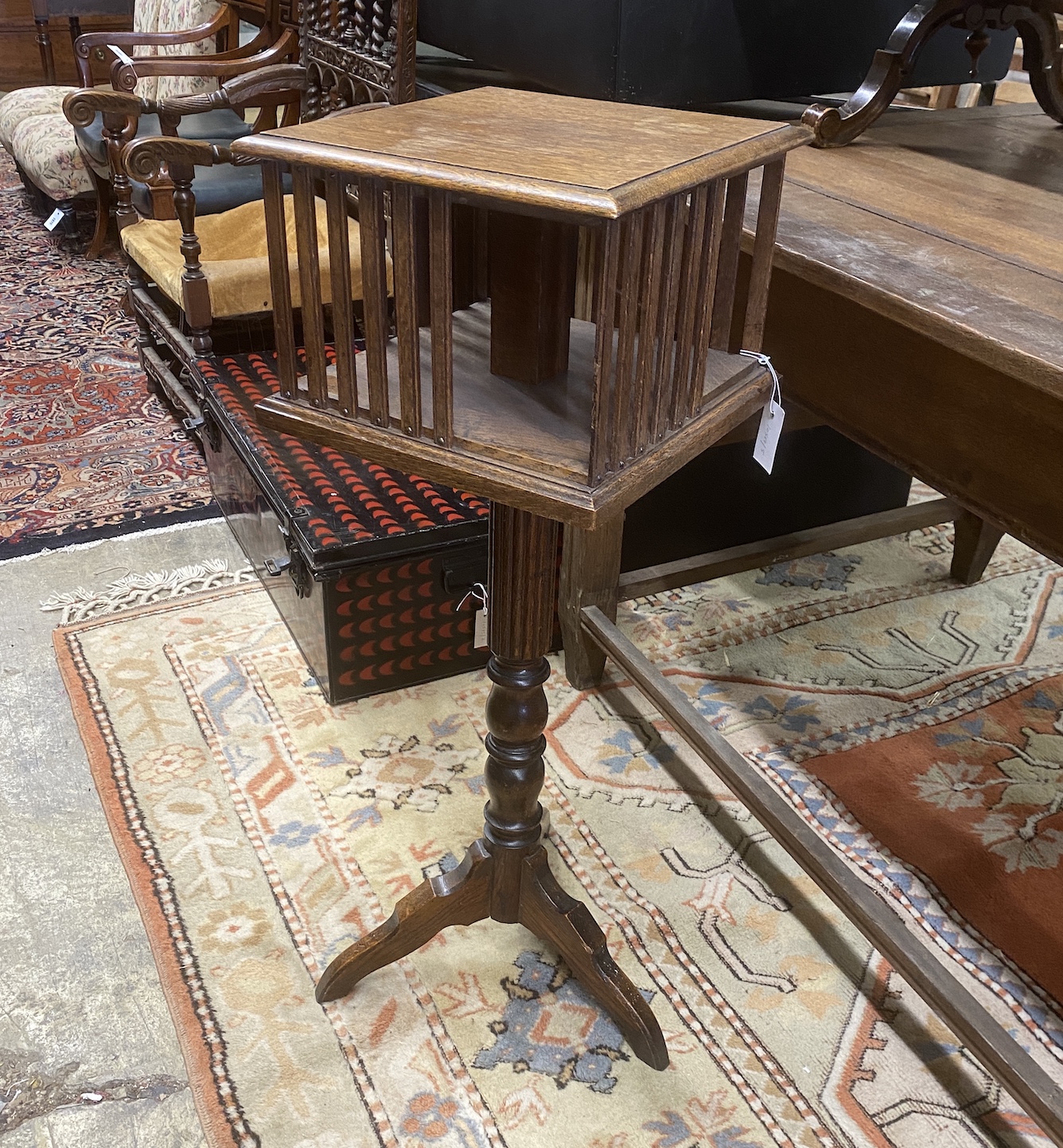 An early 20th century oak revolving bookstand on a tripod base, width 35cm, height 97cm